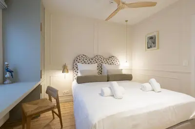 a bedroom with a white bed and a chair at SHWAY Le Pierre in Antwerp