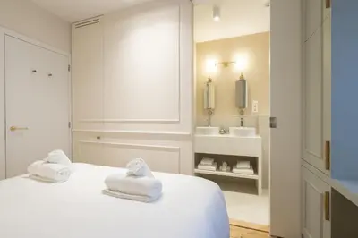 a white bedroom with towels on a bed and a sink at SHWAY Le Pierre in Antwerp