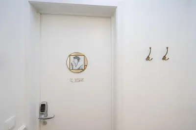 a bathroom with white walls and a door with two fixtures at SHWAY Le Pierre in Antwerp