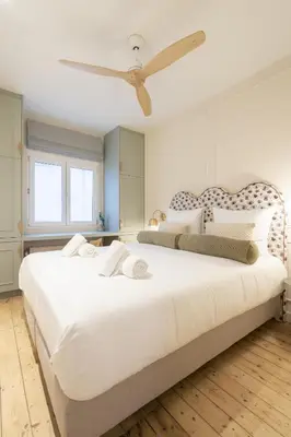 a bedroom with a large white bed with a ceiling fan at SHWAY Le Pierre in Antwerp