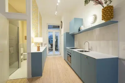 a kitchen with blue cabinets and a sink at Maison Brederode Anvers in Antwerp