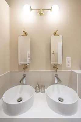 two white sinks in a bathroom with two mirrors at Maison Brederode Anvers in Antwerp