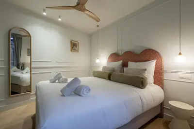 a bedroom with a white bed with a mirror at Maison Brederode Anvers in Antwerp