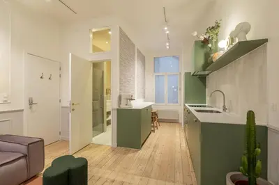 a kitchen and living room with a sink and a couch at Maison Brederode Anvers in Antwerp