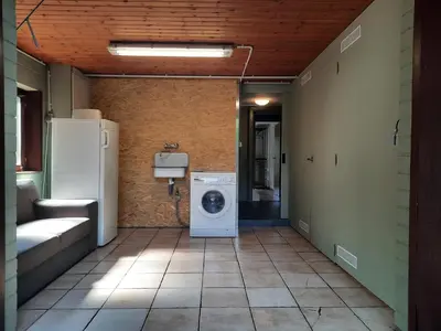 a laundry room with a washing machine and a refrigerator at Merksplas Villa with Terrace in Merksplas
