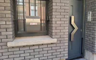 a front door of a brick building with a box in the window at Chambre deluxe au 2ème étage, chambre double au 4ème étage NOT A HÔTEL in Brussels