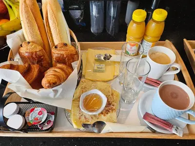 a tray of food with bread and croissants and coffee at Chambre deluxe au 2ème étage, chambre double au 4ème étage NOT A HÔTEL in Brussels