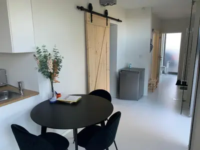 a black table and chairs in a room with a refrigerator at Prachtige gastsuite in Ranst 