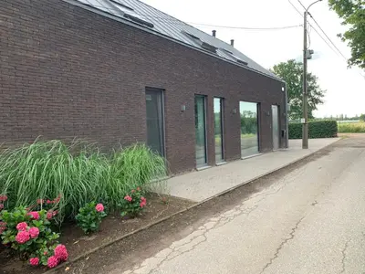 a brick building with flowers on the side of it at Prachtige gastsuite in Ranst 