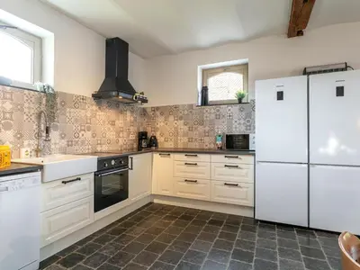 a kitchen with white appliances and a tile floor at Alverwege in Merksplas