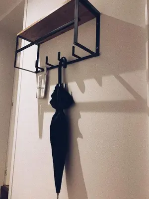 a black umbrella hanging on a wall with a light at B&B Le 36 in Brussels