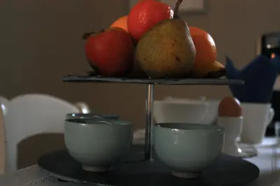 a tray of fruit on a table with two cups at B&B Le 36 in Brussels