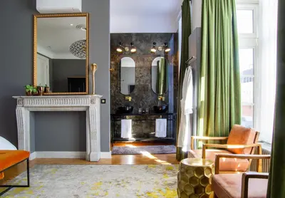 a living room with a fireplace and a mirror at The Old Beech in Antwerp