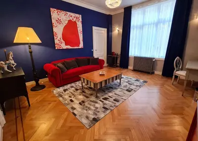 a living room with a red couch and a coffee table at The Old Beech in Antwerp