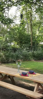a wooden picnic table with two wine glasses on it at Van Horick in Baal