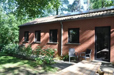 a red brick house with two chairs in the yard at Van Horick in Baal