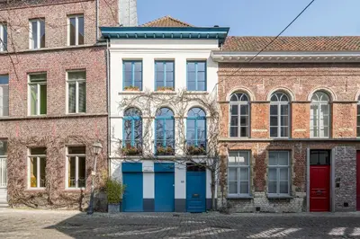an old brick building with blue doors and windows at TOP& ruim duplex woning in PATERSHOL,centrum Gent! in Ghent