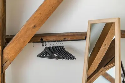 a row of hangers hanging on a wall next to a mirror at TOP& ruim duplex woning in PATERSHOL,centrum Gent! in Ghent