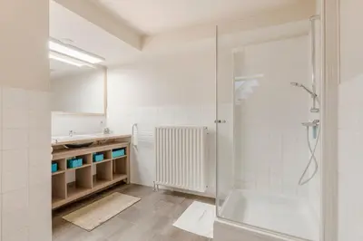 a white bathroom with a shower and a sink at TOP& ruim duplex woning in PATERSHOL,centrum Gent! in Ghent