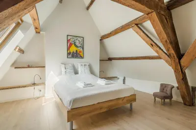 a bedroom with a bed and a chair at TOP& ruim duplex woning in PATERSHOL,centrum Gent! in Ghent