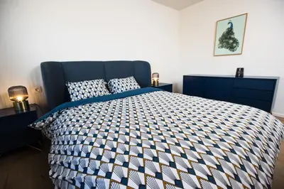 a bedroom with a bed with a blue and white comforter at The lodge Morris in Leuven