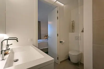 a white bathroom with a sink and a toilet at LXRYHOME Pendennis Castle in Brasschaat