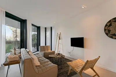 a living room with a couch and chairs and a tv at LXRYHOME Pendennis Castle in Brasschaat