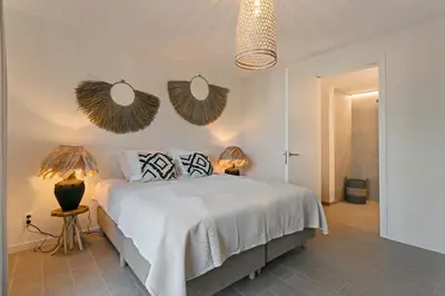 a bedroom with a bed with two lamps and two mirrors at LXRYHOME Pendennis Castle in Brasschaat