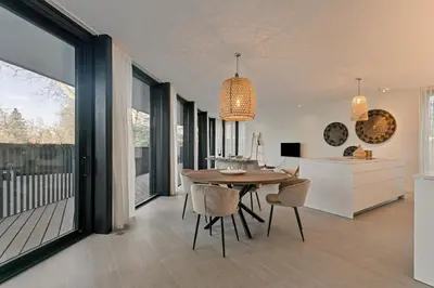 a kitchen and dining room with a table and chairs at LXRYHOME Pendennis Castle in Brasschaat