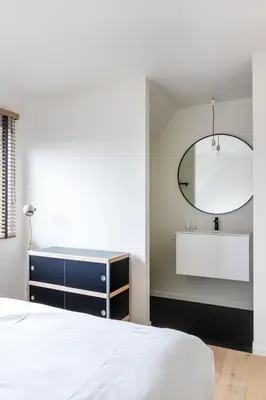 a bedroom with a white bed and a mirror at stek&stoof in Sint-Pauwels