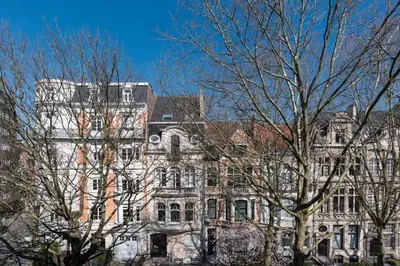 a large building with trees in front of it at Molière Design Residence in Brussels