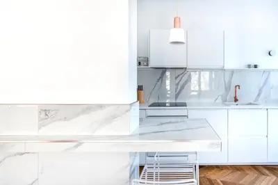 a white kitchen with white cabinets and a counter at Molière Design Residence in Brussels