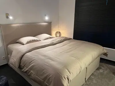 a large white bed in a room with a window at Maison Gand in Ghent