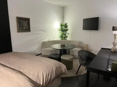 a bedroom with a bed and a table and a tv at Maison Gand in Ghent