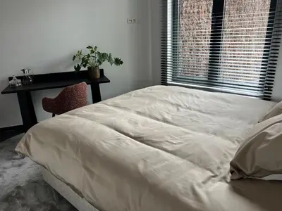 a bed in a bedroom with a table and a window at Maison Gand in Ghent