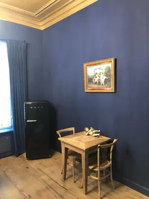 a dining room with a table and a painting on the wall at Sint Andries Suites in Antwerp