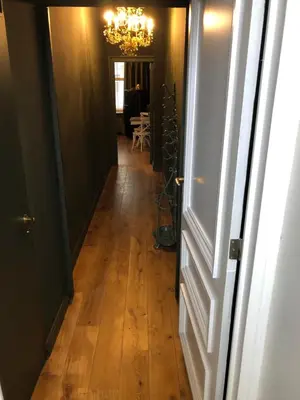 a hallway with a chandelier and a wooden floor at Sint Andries Suites in Antwerp