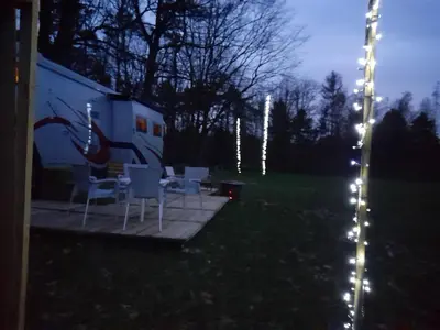 a group of white chairs and a trailer with lights at Kromven On Wheels in Merksplas