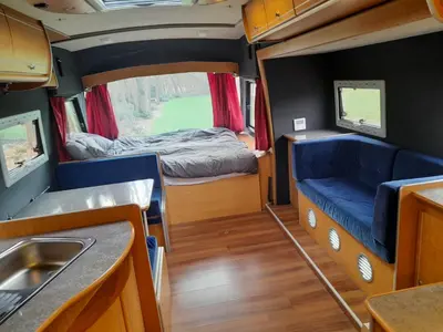 a small room with a bed and a sink in it at Kromven On Wheels in Merksplas