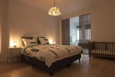 a bedroom with a bed and a chandelier at Gastenkamers huYze K in Zottegem