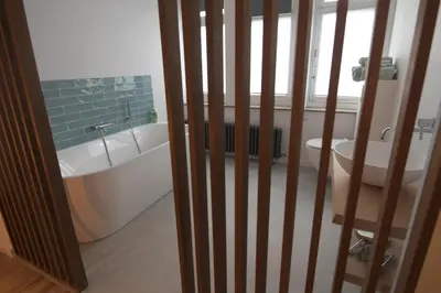 a bathroom with a tub and a toilet and a sink at Gastenkamers huYze K in Zottegem