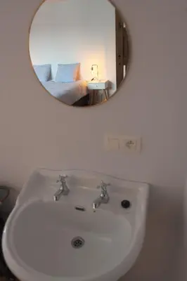 a bathroom with a white sink and a mirror at Gastenkamers huYze K in Zottegem