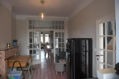 a living room with a refrigerator and a table at Gastenkamers huYze K in Zottegem