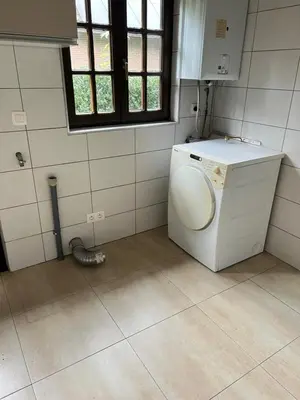a laundry room with a washing machine and a window at Panoramic Bungalow Sint Gillis-Waas in Sint-Gillis-Waas