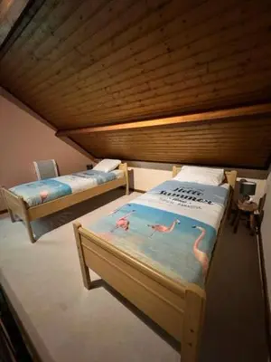 two beds in a room with a wooden ceiling at Panoramic Bungalow Sint Gillis-Waas in Sint-Gillis-Waas