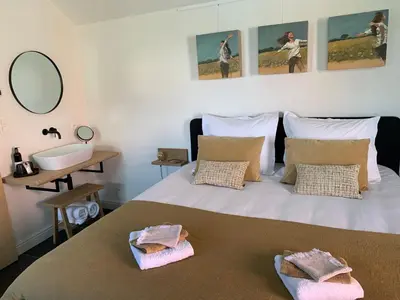 a bedroom with a bed with a sink and a mirror at B&B 't klein GELUK in Ham