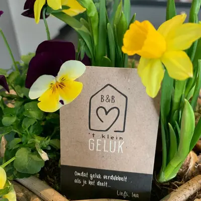 a sign in a bunch of flowers at B&B 't klein GELUK in Ham