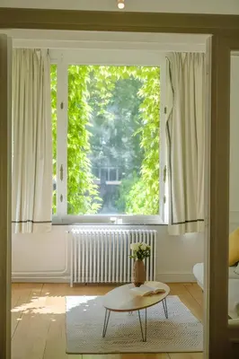 a living room with a large window and a coffee table at La Calamande En Ville in Brussels