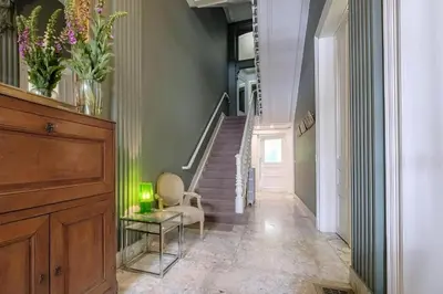 a hallway with a staircase with a chair and a table at La Calamande En Ville in Brussels