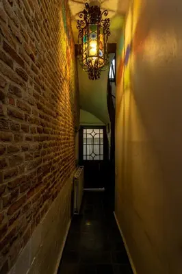 a hallway with a brick wall and a chandelier at Coeur Saint-Jacques in Brussels